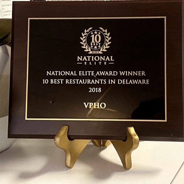 A dark brown plaque on a gold stand, recognizing vPho as a 2018 National Elite Award Winner.