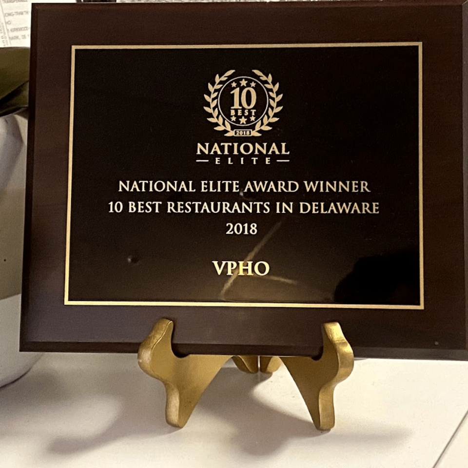 A dark brown plaque on a gold stand, recognizing vPho as a 2018 National Elite Award Winner.